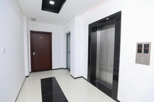 a hallway with black doors and white walls at ماجيك سويت بوليفارد Magic Suite Boulevard in Kuwait