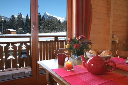 a table with a tea pot and a candle on a balcony at Résidence Néméa Les Chalets du Bois de Champelle in Morillon