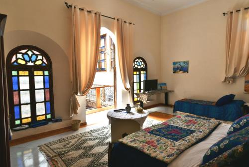 メクネスにあるRiad Dar AlKATIB Meknèsのベッドルーム1室(ベッド1台、窓2つ付)