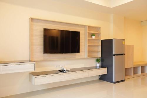 a kitchen with a refrigerator and a flat screen tv at Lampang Residence in Lampang