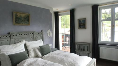ein Schlafzimmer mit einem weißen Bett und einem Fenster in der Unterkunft Die schlafende Goass - Pub und Gästehaus in Bischofswiesen