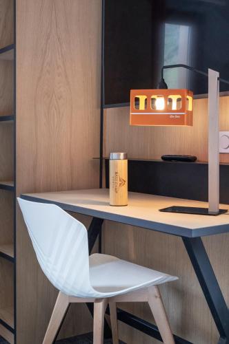 a desk with a chair and a cup on it at Hotel Base Camp Lodge - Bourg Saint Maurice in Bourg-Saint-Maurice