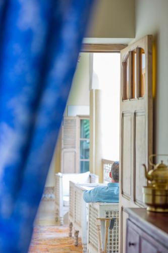 a man sitting at a table in a room at Riad Azoulay in Marrakech