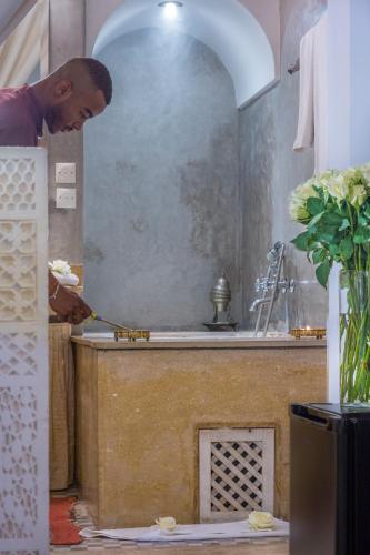 a man standing in a kitchen preparing food at Riad Azoulay in Marrakech