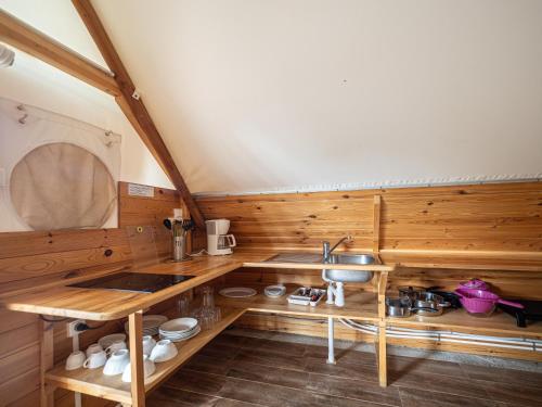cocina con paredes de madera y lavabo en una habitación en Camping L'Orangeraie, en Cálig