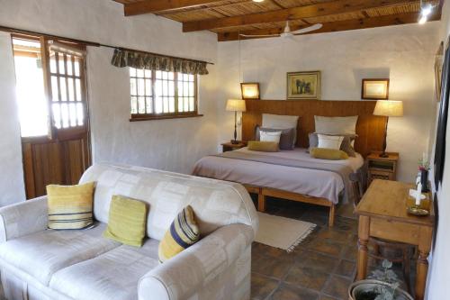 sala de estar con 2 camas y sofá en The Retreat at Groenfontein, en Calitzdorp