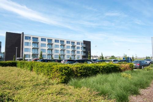 a parking lot with cars parked in front of a building at Acropolis - Luxury Appartments I Hotelservice and parking in Middelkerke