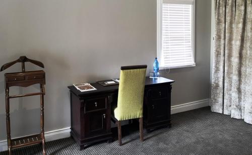 a desk with a yellow chair next to a window at Premier Resort Mpongo Private Game Reserve in Macleantown