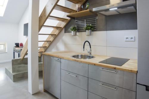 eine Küche mit einem Waschbecken und einer Treppe in der Unterkunft caput mundi in Krakau