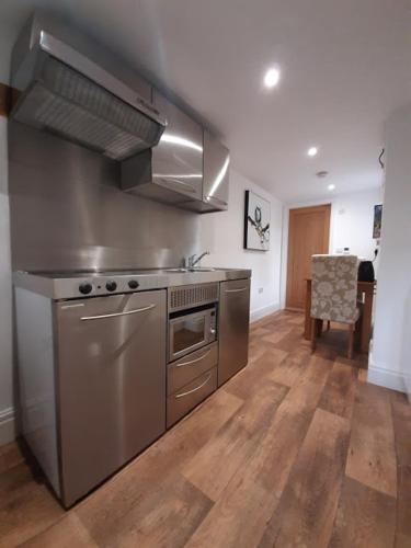 a kitchen with stainless steel appliances and a wooden floor at The Rectory Rooms, Studio 4 in Skipton