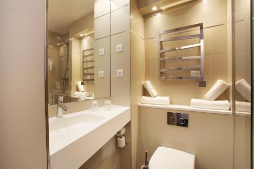 a bathroom with a sink and a mirror at Hotel Apolonia Paris Mouffetard, Sure Hotel Collection by Best Western in Paris