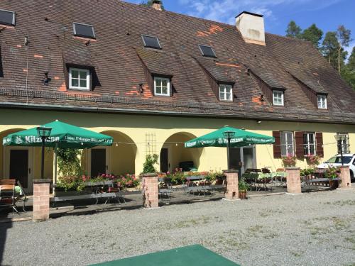 a building with tables and umbrellas in front of it at Jugendhotel Nürnberg in Nürnberg