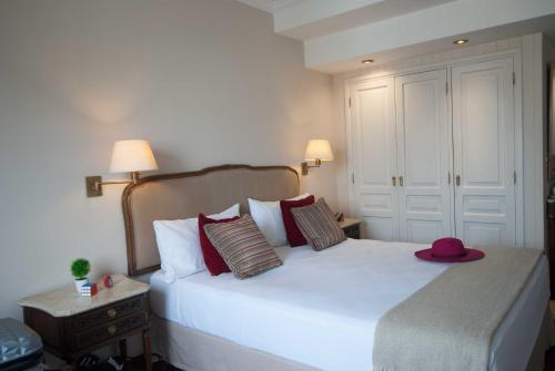 a bedroom with a white bed with a hat on it at Ramada by Wyndham Buenos Aires Centro in Buenos Aires