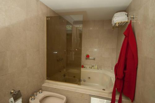 a bathroom with a shower and a toilet and a tub at Ramada by Wyndham Buenos Aires Centro in Buenos Aires