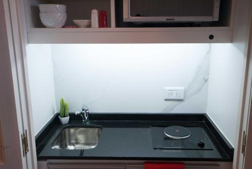 a small kitchen with a sink and a microwave at Ramada by Wyndham Buenos Aires Centro in Buenos Aires