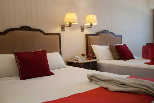 a hotel room with two beds with red and white pillows at Ramada by Wyndham Buenos Aires Centro in Buenos Aires