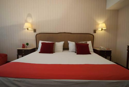 a bedroom with a large bed with red and white pillows at Ramada by Wyndham Buenos Aires Centro in Buenos Aires