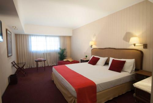 a hotel room with a large bed with red pillows at Ramada by Wyndham Buenos Aires Centro in Buenos Aires