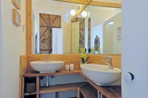 a bathroom with two sinks and a large mirror at Localtraveling ALFAMA River View - Family Apartments in Lisbon