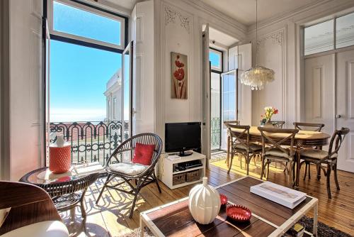 a living room with a table and a dining room at Localtraveling ALFAMA River View - Family Apartments in Lisbon