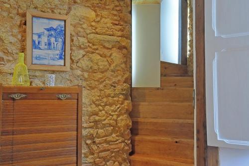 a room with a stone wall and a wooden door at Localtraveling Historic Center Travessa in Lisbon