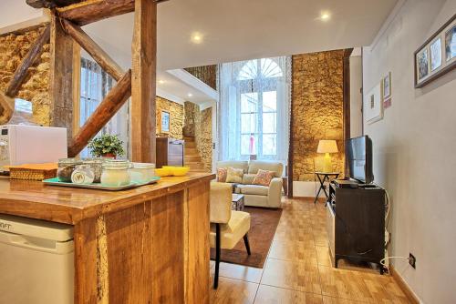 a kitchen with a counter and a living room at Localtraveling Historic Center Travessa in Lisbon