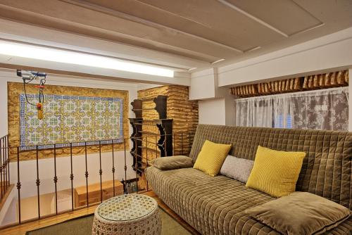a living room with a couch with yellow pillows at Localtraveling Historic Center Travessa in Lisbon