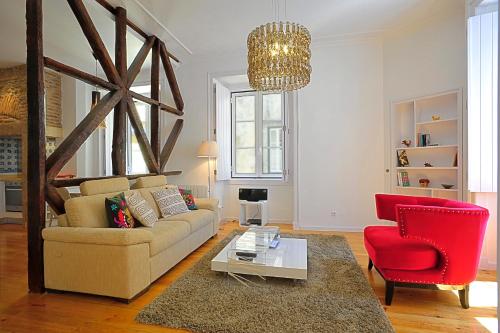 a living room with a couch and a red chair at Localtraveling Historic Center Travessa in Lisbon