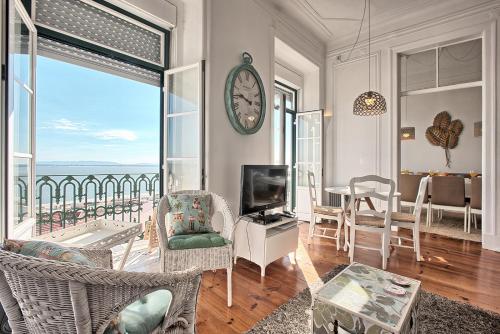 a living room with a clock on the wall at Localtraveling ALFAMA River View - Family Apartments in Lisbon