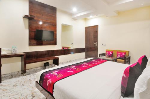 a bedroom with a large bed and a flat screen tv at The Grand Uddhav in New Delhi