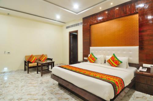 um quarto com uma cama grande e uma secretária em The Grand Uddhav em Nova Deli