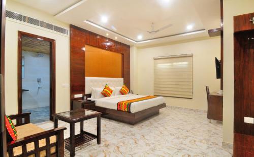 a hotel room with a bed and a bathroom at The Grand Uddhav in New Delhi