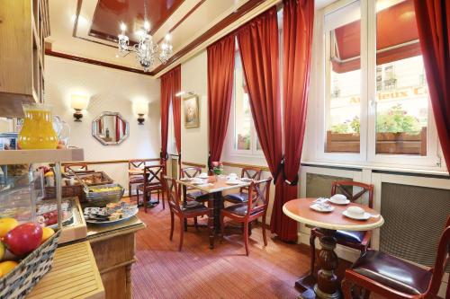 cocina y comedor con mesas y ventanas en Hotel du College de France en París