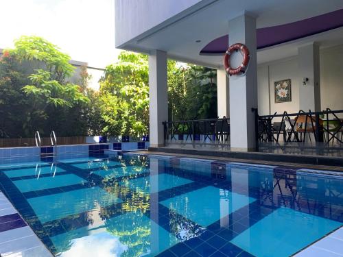 una piscina con azulejos azules en el suelo y una casa en Pacific Hotel Ambon en Ambon