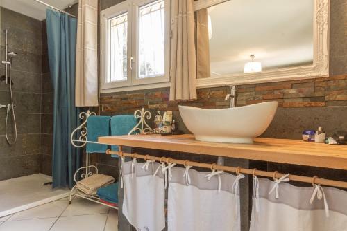 une salle de bain avec un lavabo et un miroir dans l'établissement Maison Beally, à Eyragues