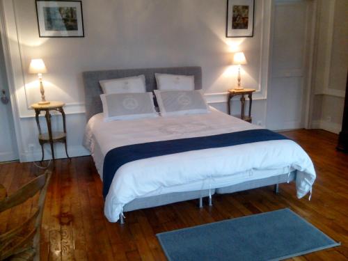 ヌフムーティエ・アン・ブリにあるChambres d'hôtes La Bourbelleのベッドルーム1室(大型ベッド1台、ランプ2つ付)