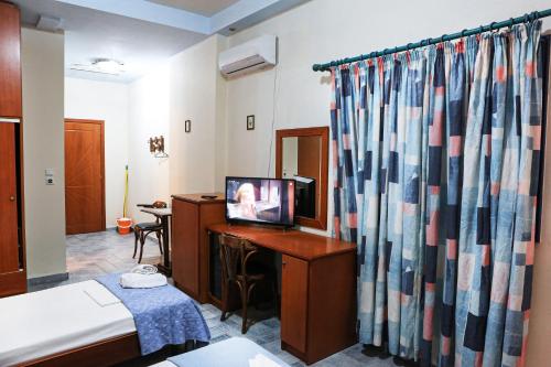 a room with a bed and a television on a desk at Hotel Hlidi in Kokkino Nero