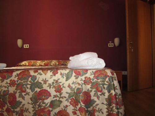 ein Hotelzimmer mit einem Bett mit Blumenbettdecke in der Unterkunft Hotel Genzianella in Florenz