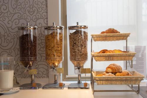 a table with three shelves of bread and other food items at Hotel Vittoria in Genova
