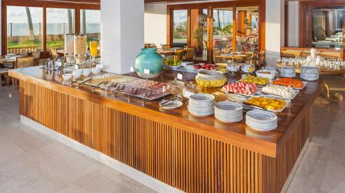 a buffet line with food on it in a restaurant at Jatiuca Hotel & Resort in Maceió