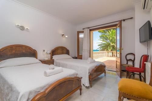 a bedroom with two beds and a balcony at Chilllife in Port d'Alcudia