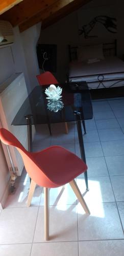 a red chair and a black table with a flower on it at Alexia's Apartments in Rio