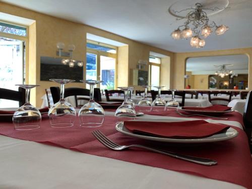 a table with red napkins and wine glasses on it at Hôtel des Bains et des Gorges in Amélie-les-Bains-Palalda