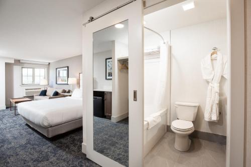 a hotel room with a bed and a bathroom at Pomeroy Hotel Fort McMurray in Fort McMurray