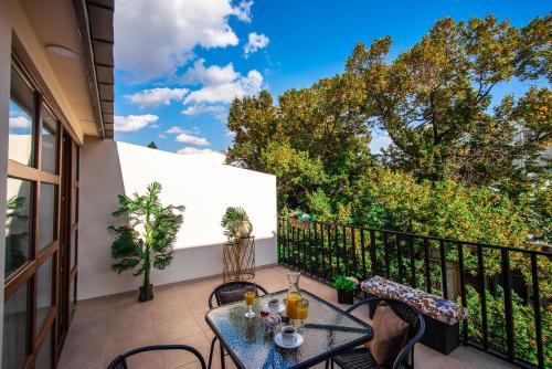 Un patio con una mesa y sillas en un balcón. en Margi Boutique Hotel by DNT Group, en Tiflis