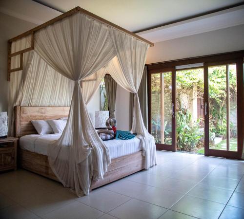 a bedroom with a bed with a canopy at Ratna Villa in Ubud