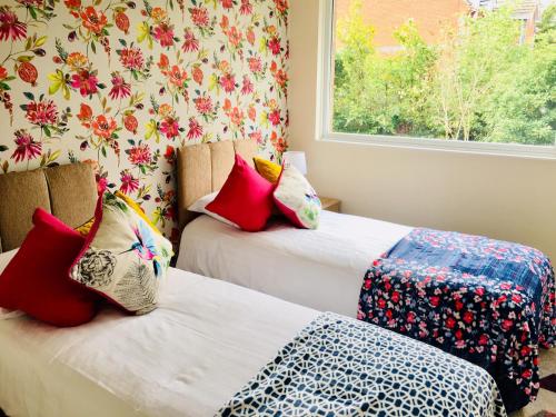 - 2 lits dans une chambre avec fenêtre dans l'établissement Homely Birch Close House with Free Parking,Garden & Sleeps 8, à Cambridge