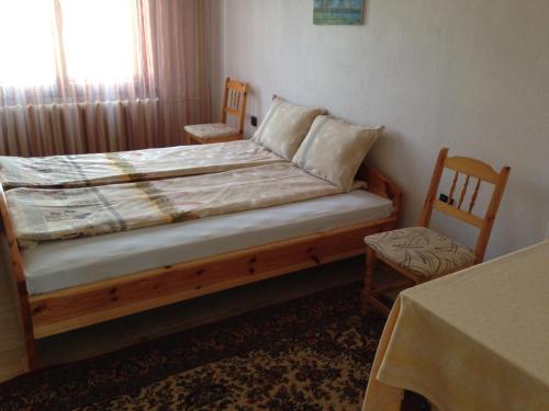 um quarto com uma cama com 2 cadeiras e uma janela em Katya Guest House em Smolyan