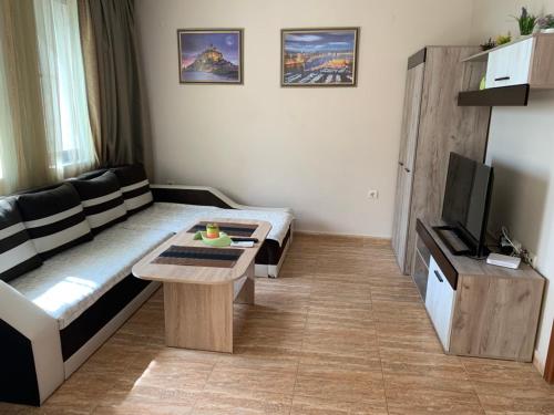 a small living room with a couch and a tv at Jacky's Apartament - Апартамент в Свети Влас in Sveti Vlas