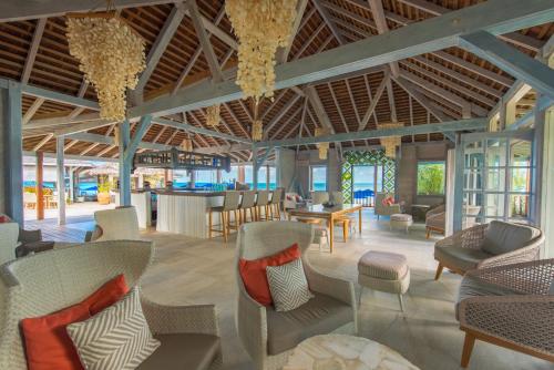 a lobby with chairs and tables and a bar at Cocobay Resort Antigua - All Inclusive - Adults Only in Johnsons Point